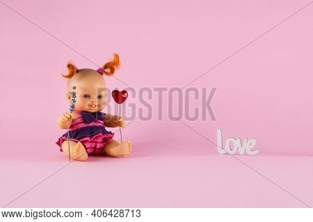 Freckled White Doll Girl With Two Curly Red Tails Holds A Heart And A Sprig Of Lavender On A Pink Ba