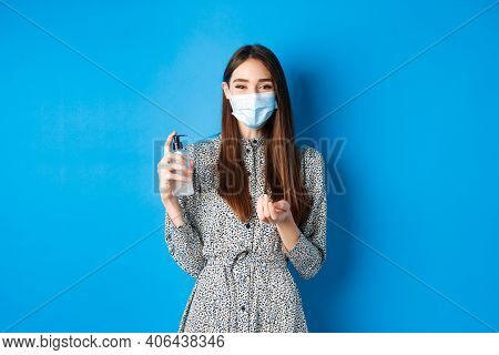 Covid-19, Social Distancing And Healthcare Concept. Beautiful Girl In Medical Mask Using Hand Sanizi