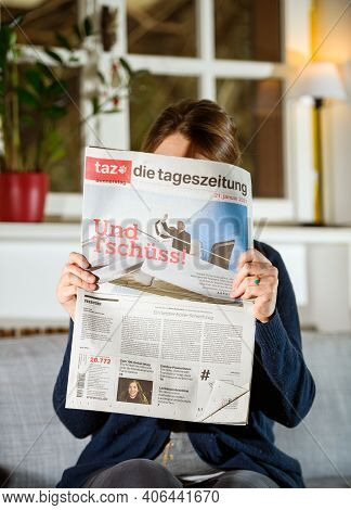 Paris, France - Jan 21, 2021: Woman Reading German Taz Newspaper With Donald Trump Leaving As A Form