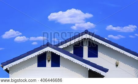 Front View Of Blue Fiber Cement Tile Roof In Different Level With Dripping Eave On White Wooden Hous
