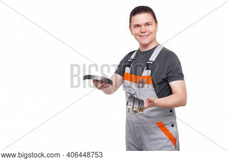 Male Employee In Gray Uniform Of Car Mechanic Worker With Spanner Wrench In Pocket Holds Brake Shoes