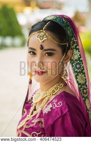 Portrait Asian Woman In A Margenta Indian Tradition Sari, She Is Looking At A Camera Next To The Whi