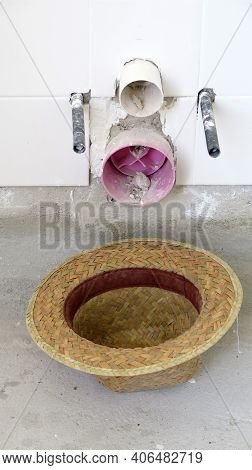 Laborers Strawhat Upside Down Below Exposed Lavatory Pipes