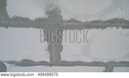 Roller And Foam Block. A Construction Roller With A Fur Nozzle On The Background Of A Wall Made Of A