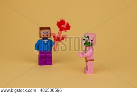 Ukraine, Kyiv - April 3, 2020: A Toy Man Gives A Girl Flowers. Toys. Valentine's Day, 8 March. Lego