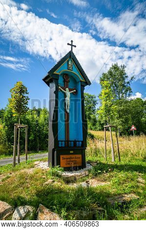Haj, Czech Republic - July 6 2018: The Blue And Brown Wooden Steinmüller Cross With White Jesus Plas