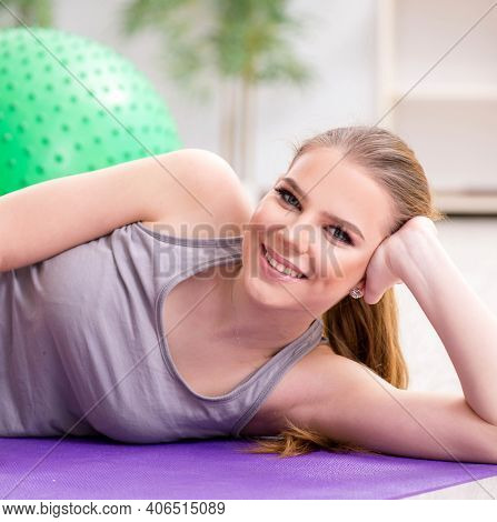 Young woman exercising with stability ball in gym