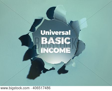 Text Universal Basic Income In White Bold Letters Appearing From Paper Hole. Unconditional Basic Inc