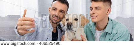 Cheerful Same Sex Couple Smiling And Taking Selfie With Labrador, Banner.