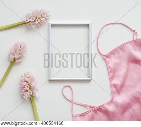 Styled Feminine Flat Lay With Blank Photo Frame, Silk Lingerie And Pink Flowers On White Background.