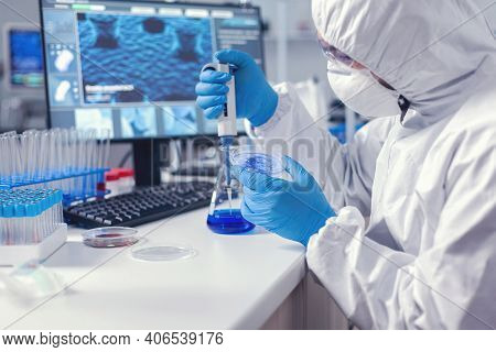 Chemist Engineer Conducting Experiement With Micropipette And Petri Dish Dressed In Coverall. Chemis
