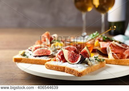Sandwiches With Figs, Proscuitto And Cheese On Wooden Table, Closeup