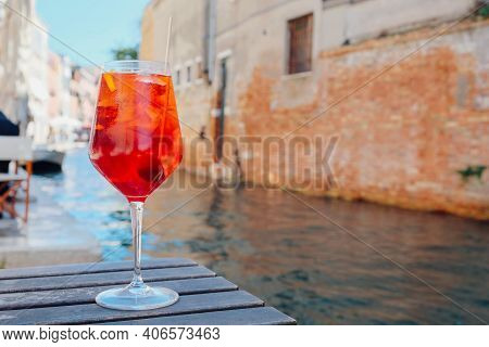 Glass of refreshing Aperol Spritz cocktail served on the deck bar in Venice. Traditional venetian ap