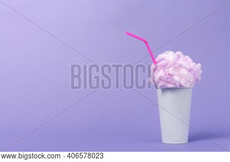 Conceptual image of milkshake with pink foam on viiolet background