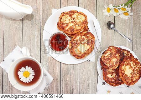 Delicious Russian Pancakes With Cherry Jam And Chamomile Herbal Tea On A Bright Light Table. Healthy