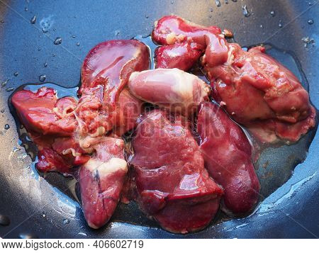 Chicken Liver, Kidney And Heart In A Non-stick Skillet. The Offal Of The Bird Is Placed In A Dark Bo