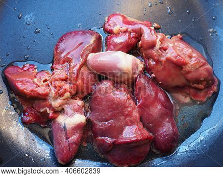 Chicken Liver, Kidney And Heart In A Non-stick Skillet. The Offal Of The Bird Is Placed In A Dark Bo