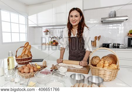 Asian Middle-aged Woman Kneading Dough For Baking Happy And Smile In The Home Kitchen. Concept Desse