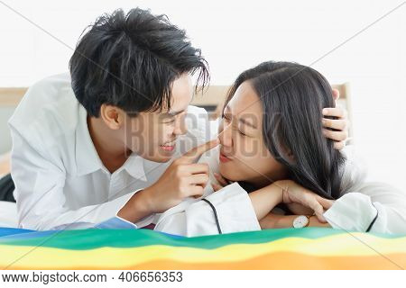 Lgbtq Couple Lovers, A Handsome Girl As A Man Or Butch Femme Girl Laying On A Bed With The Rainbow F