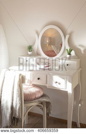 Detail of makeup dressing table with large mirror, diary and organizer. White and clean workstation in the master bedroom. Nobody inside.