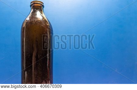 Old Edible Oil Storage Glass Bottle On Blue Background