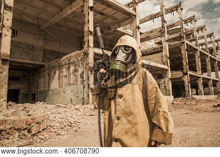 Boy Stands With A Gun In His Hand. Boy In A Gas Mask. \ra Young Man In A Protective Cloak And Hood. 