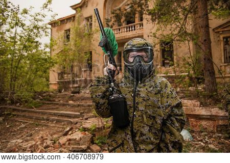 Boy Stands With A Gun In His Hand. Boy In A Gas Mask. \ra Young Man In A Protective Cloak And Hood. 
