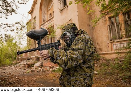 Boy Stands With A Gun In His Hand. Boy In A Gas Mask. \\ra Young Man In A Protective Cloak And Hood.
