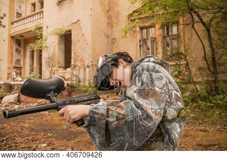 Boy Stands With A Gun In His Hand. Boy In A Gas Mask. \\ra Young Man In A Protective Cloak And Hood.