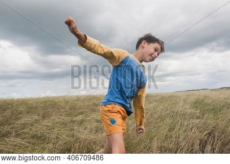 Boy In Shorts Stands In The Field. Boy Looks To The Sky. Dreamer Guy