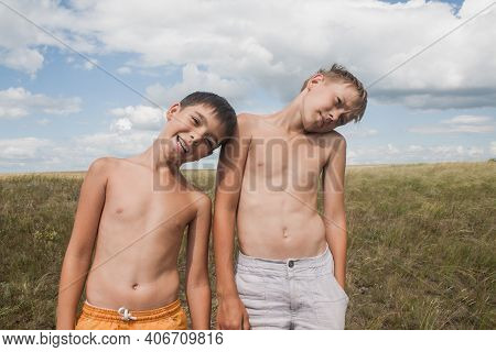 boys standing in a field . Boys in shorts.   two friends. children playing in the field.