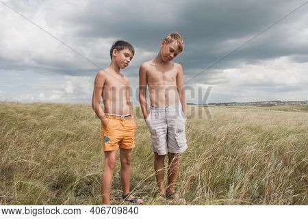Boys Standing In A Field . Boys In Shorts.   Two Friends. Children Playing In The Field.