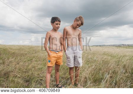 Boys Standing In A Field . Boys In Shorts.   Two Friends. Children Playing In The Field.