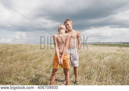Boys Standing In A Field . Boys In Shorts.   Two Friends. Children Playing In The Field.