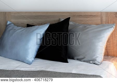 Three Pillows In Silk Pillowcases On The Bed. Detail Of The Interior Close Up.