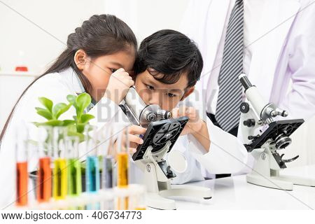 Young Asian Kids Wearing White Scientist Gown And Do Chemical Test Tube While Study, Learning In Sci