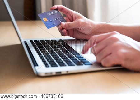 Men Hand Holding Credit Card And Type Payment Information On Keyboard For Order Online Shopping. Int