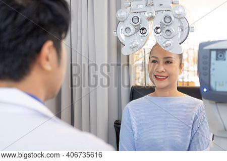 Selective Focus At Optometry Frame Equipment. While Doctor Using Penlight And Subjective Refraction 