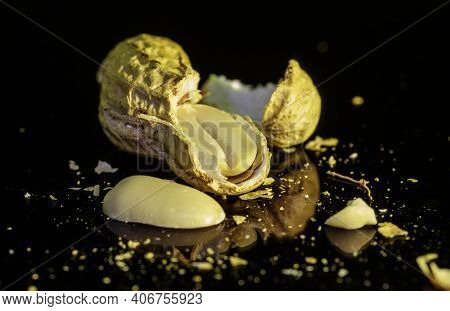 Peeled Peanut Resting On A Black Reflective Background.