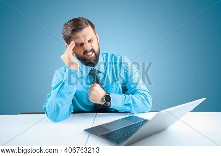 A Bearded Businessman At A Laptop Leaned His Hand To His Head He Has Severe Headaches, A Man Sitting