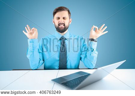 Bearded Businessman Meditates In The Office At The Computer
