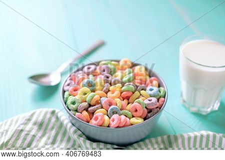 Colored Fruit Grain Loops With A Glass Of Milk On The Table. Breakfast Concept
