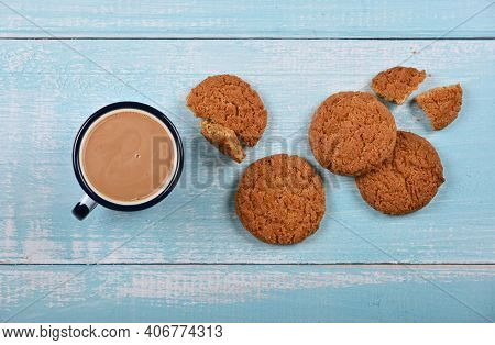 Close Up Several Round Artisan Oatmeal Cookies And Pannikin Mug Of Hot Chocolate On Blue Painted Rus