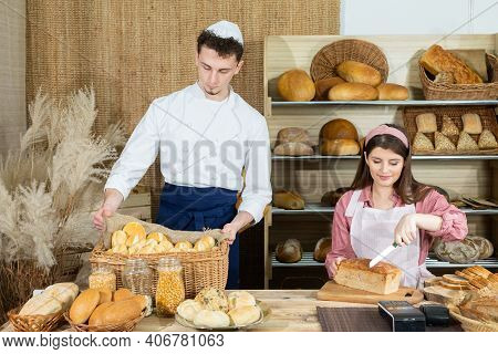 Before The Arrival Of Customers, The Baker Corrects The Arrangement Of The Bread And The Young Sales