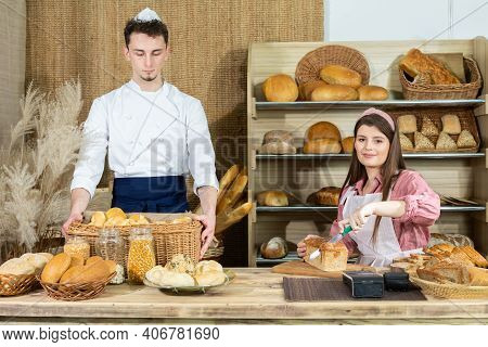Before The Arrival Of Customers, The Baker Corrects The Arrangement Of The Bread And The Young Sales