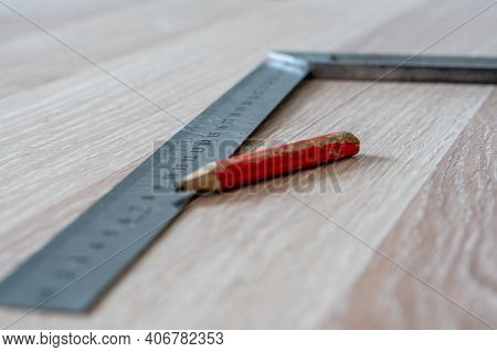 Red Carpenter's Pencil And Right Angle's Tool On Laminate Floor After Renovation Or Reconstruction W