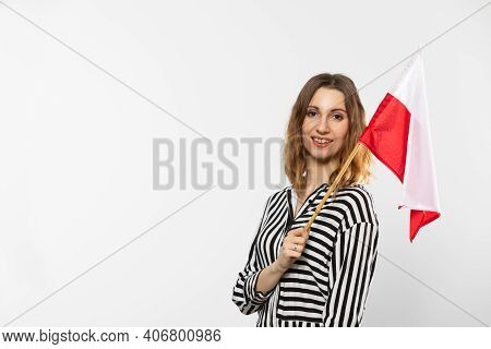 A Smiling Girl Holds One Polish National Flag In Her Hand. Isolated From The Background.