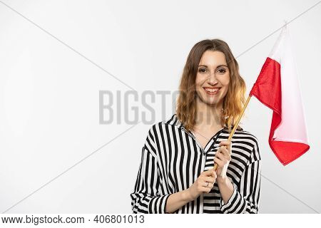 A Smiling Girl Holds One Polish National Flag In Her Hand. Isolated From The Background.