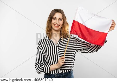 A Smiling Girl Holds One Polish National Flag In Her Hand. Isolated From The Background.