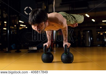 The Man Performs A Complex Acrobatic Trick - Horizontal Rack On Weights. Focus On Sports. Concentrat